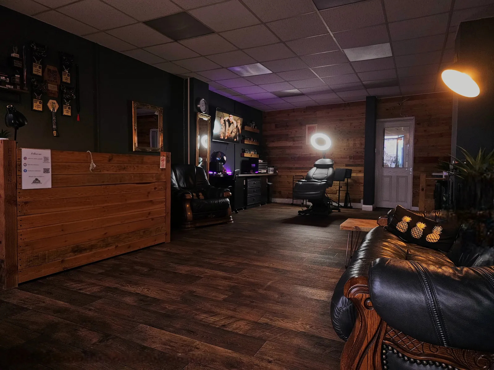 Inside Aloha Tattoo Studio, Gloucester: wooden reception, leather sofas and tattoo chair